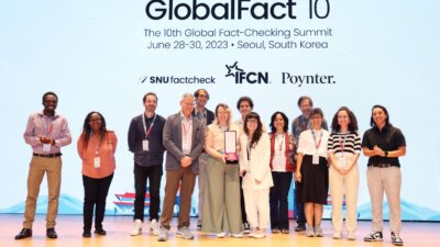 Members of Confirma 2022 receive their collaboration award at the GlobalFact 10 ceremony. Flanking the group are IFCN's Enock Nyariki (extreme left) and Alanna Dvorak (extreme right), who presented the trophy. (Courtesy: IFCN)