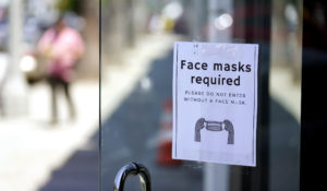 A sign advises shoppers to wear masks outside of a store Monday, July 19, 2021, in the Fairfax district of Los Angeles. Los Angeles County has reinstated an indoor mask mandate due to rising COVID-19 cases, largely caused by the highly contagious delta variant. (AP Photo/Marcio Jose Sanchez)